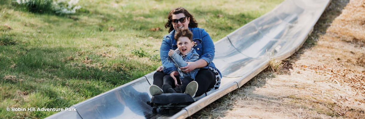 Mum and son riding on the toboggan at Robin Hill Adventure Park on the Isle of Wight
